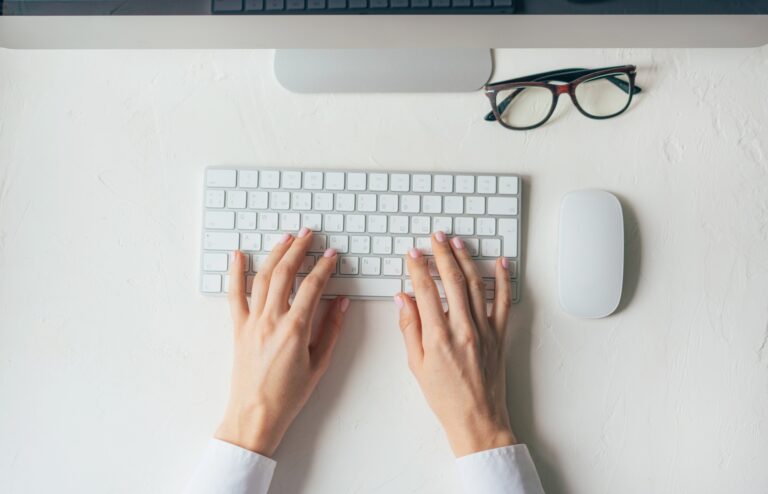 Minimalistic workspace with a computer keyboard. Hands typing on keyboard, business content.